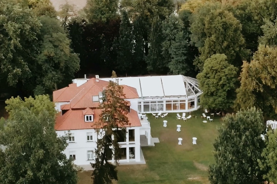Rezydencja weselna z lotu ptaka, w ogrodzie krzesła i stoliki dla gości